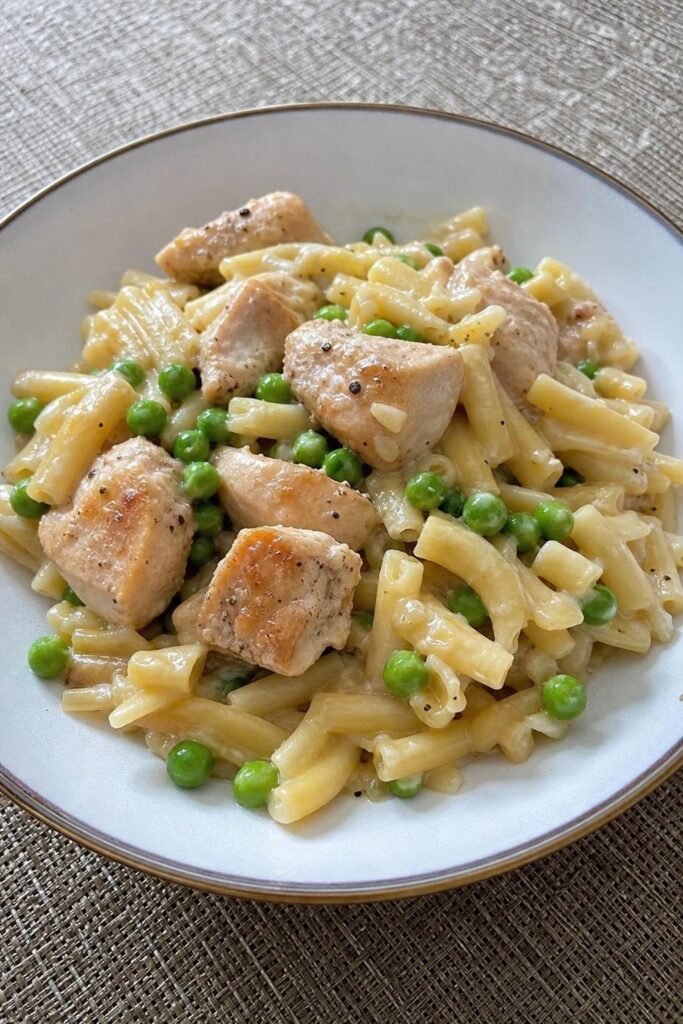 Chicken thigh cutlets in cream with peas and pasta from one pan